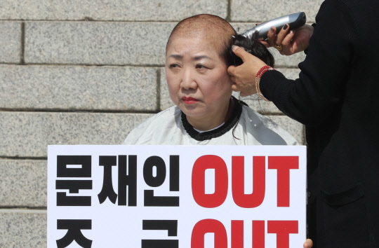 박인숙 자유한국당 의원이 11일 국회 본청 앞 계단에서 조국 법무부 장관 해임을 요구하며 삭발하고 있다. 연합뉴스